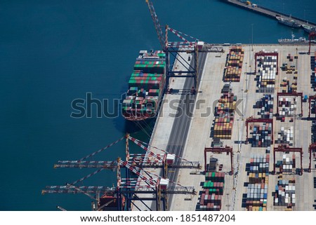 Aerial view of a container ship moored at a commercial dock.