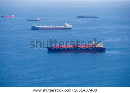 Wide shot of the side view of a natural gas cargo ship travelling at the sea.