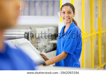 Portrait of a Technician smiling and operating machinery in a solar panel factory