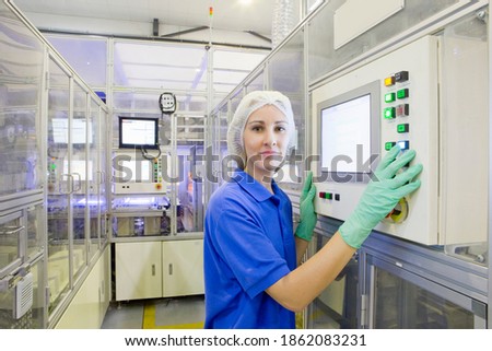 Technician controlling automated production line on the factory floor