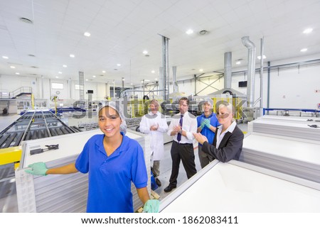 Employee team applauding for a technician in a solar panel factory