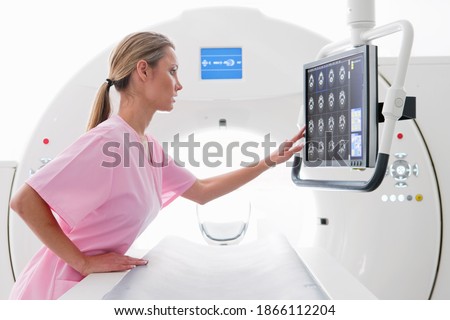 A nurse reviewing the digital scan of a patient displayed on the monitor in the hospital