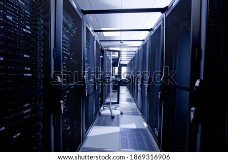 Computer in an aisle with server cabinets at a data center.