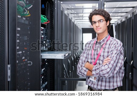 Portrait shot of a young technician replacing a server in the server cabinet.