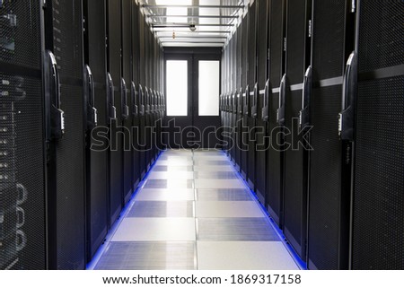 Servers stored in cabinets along the aisle of a data center.