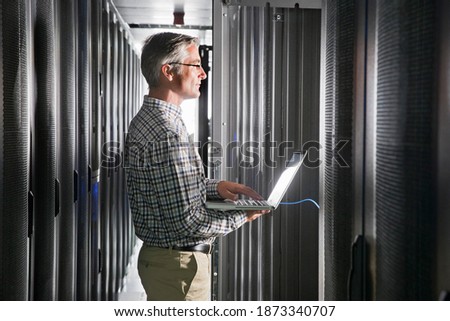 Technician With a Laptop Working In the Secured Data Centre