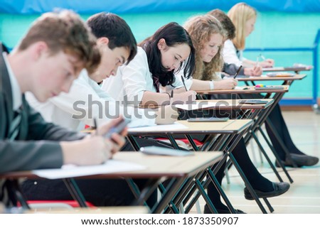 Close up of focused middle school students taking examination at desks