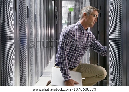 Technician With a Laptop checking the secured data center