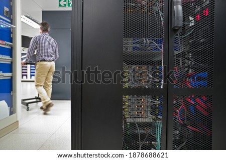 Back shot of a Technician Working on a Laptop In the secured data center