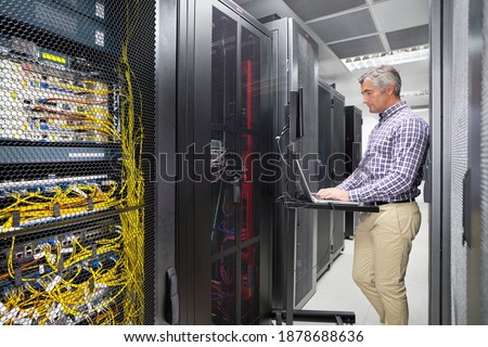 Technician Working on a Laptop In the secured data center