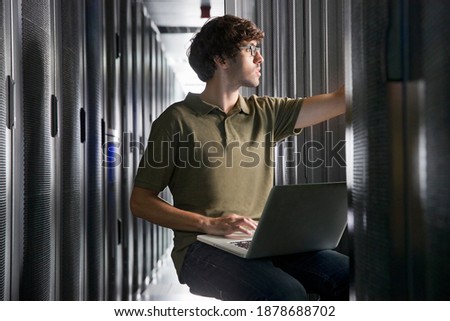 Technician with a laptop working in the secured data center