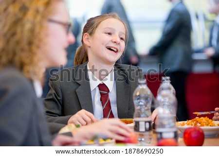 Portrait shot of a middle school student eating lunch in the school cafeteria.