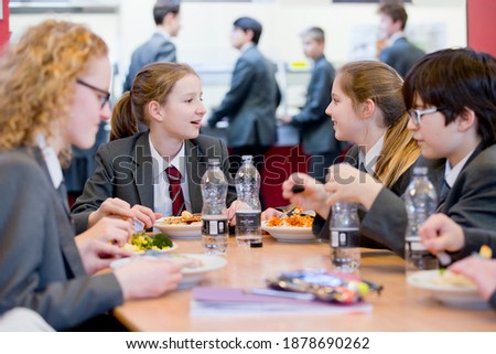 A group of middle school students eating lunch in the school cafeteria.