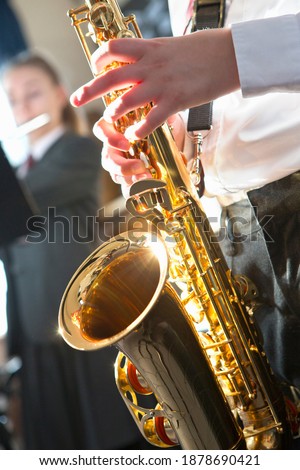 Close-up shot of a high school student playing saxophone during a music class.