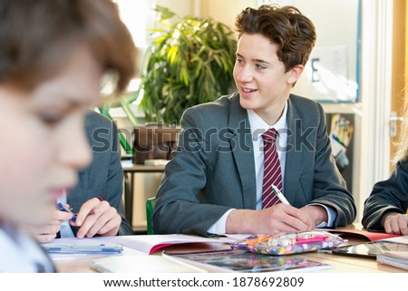 High school student completing his homework in the study hall.