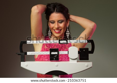 Happy woman on a medical weight scale.