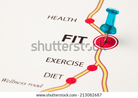 Conceptual image where fit is the target of the wellness road. Exercise, diet and health are cities of the road. Selective focus on thumbtack.