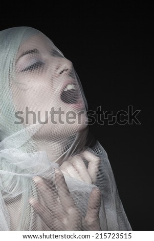 Woman with a veil screaming. Low key.