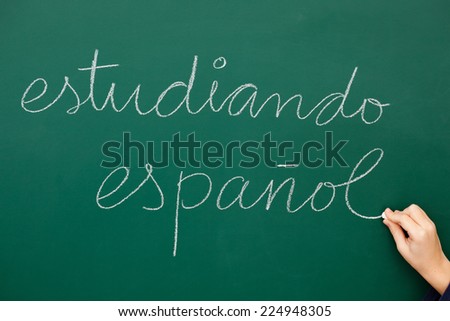 Man writing studying spanish on the backboard. Estudiando espaÃ?Â±ol escrito en una pizarra.