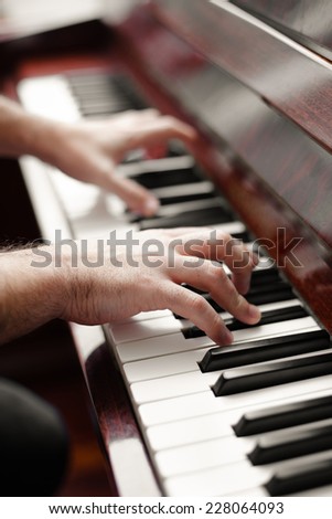 Pianist man playing piano. Selective focus o foreground hand.
