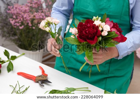 Florist making a bouquet. Selective focus on bouquet.