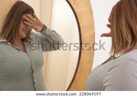 woman rejecting her self image in the mirror.