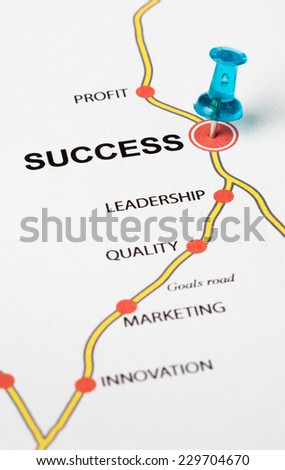 Success as target in the goals road. Conceptual image where the cities are the principles that lead to the success target. Selective focus on the thumbtack.