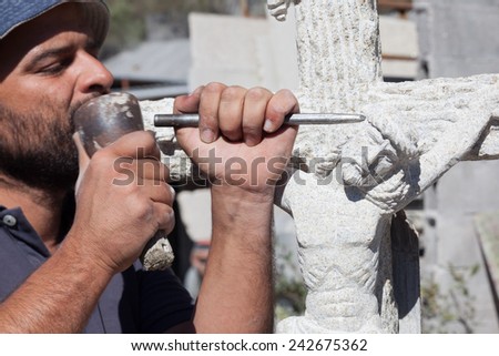 Sculptor working on a Jesus stone sculpture.