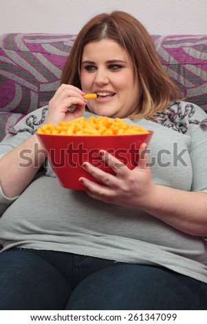 woman eating junk food on the couch.