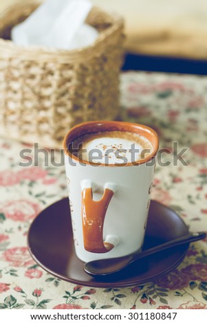Cup of coffee on the table cloth floral vintage style, vintage style photo.