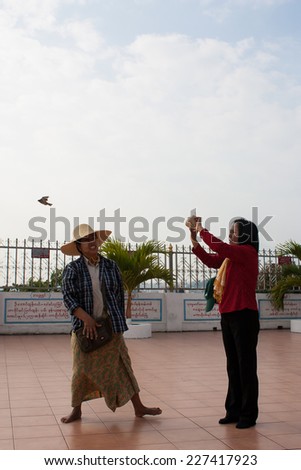 BANGKOK , THAILAND - DECEMBER 8 : Unidentified women  set a bird free to nature on December 8 , 2009 in a temple , Bangkok , Thailand. Set a bird is a how to make merit in Buddhisms.