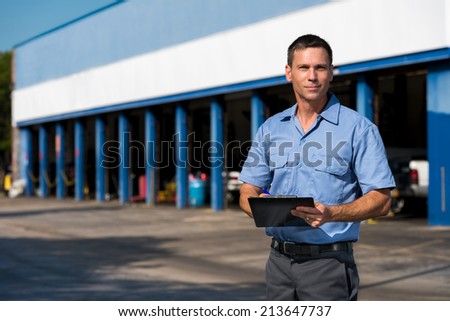 Auto Mechanic with Clipboard at Work