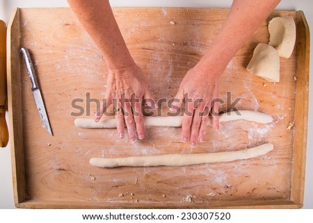 Rolling out the dough on a board in the kitchen