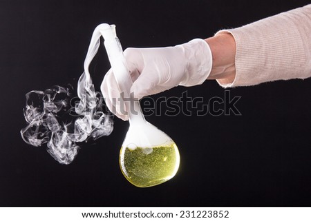 Chemical reaction in volumetric flask glass kept in the hands of scientist