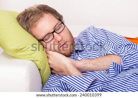 Young man sleeping on the couch - studio shoot