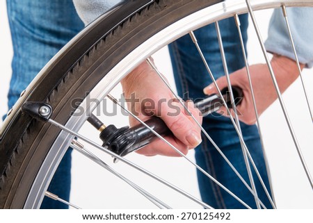 Woman pumping on a bicycle wheel - studio shoot