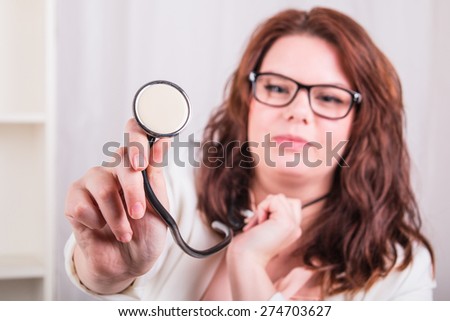 Young female doctor with a stethoscope examines - doctor\'s office