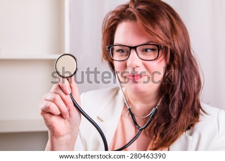 Young female doctor with a stethoscope examines - doctor\'s office