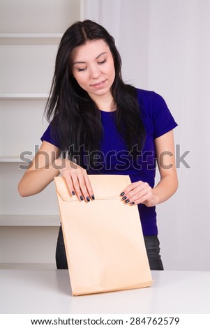 Woman tape the large envelope with documents before sending