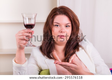Woman at home tests glass of red wine - studio shoot