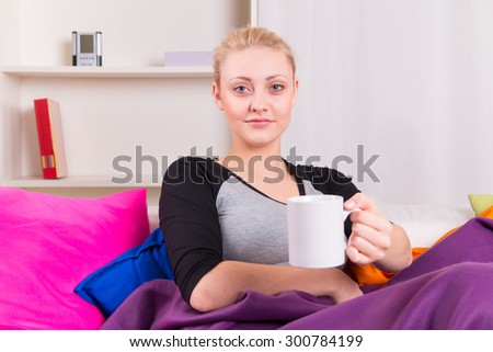 Women sitting on the sofa with cup of tea at home