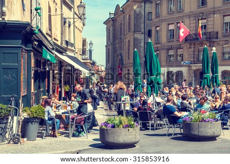 Geneva, Switzerland - April 10, 2015: Bourg-de-Four Square in Geneva old town and restaurant full of people