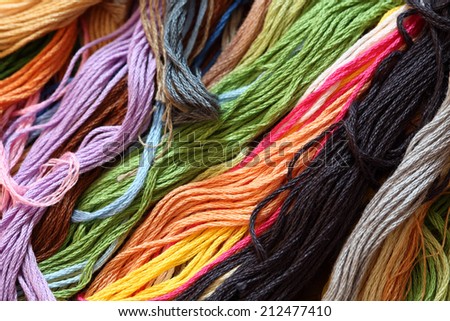 Colorful cross-stitch threads background. Close-up.