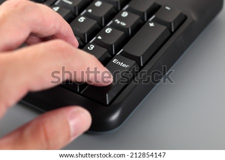 Man\'s hand typing on Numeric keypad of the black computer keyboard. Close-up.