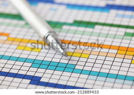 Project Plan (Gantt chart) and ballpoint pen on it. Close-up.