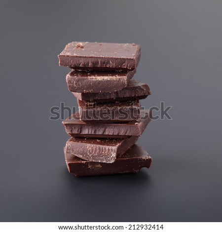 Pieces of dark chocolate. Black background. Close-up.
