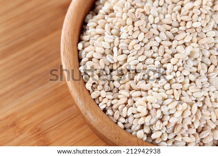 Pearl barley is in a wooden bowl. Close-up.