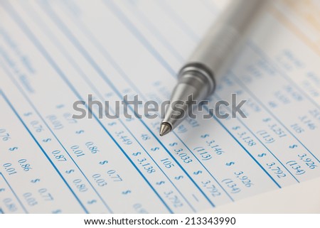 Ballpoint pen on financial statements.