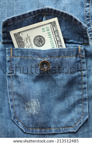 One hundred dollar in the denim shirt pocket. Closeup.