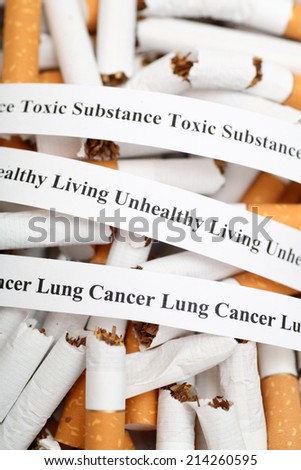 Stop Smoking! Heap of broken cigarettes and warning messages. Closeup.